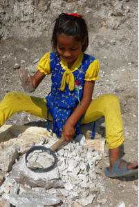Child Smashing Rocks to Build New School